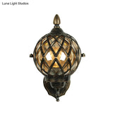 Amber Glass Wall Sconce With Industrial Cage And Black Globe For Dining Room Lighting