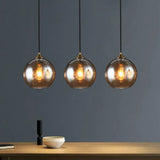 Antiqued Brass Globe Pendant Lamp With 3 Lights And Glass Shade Amber / Linear