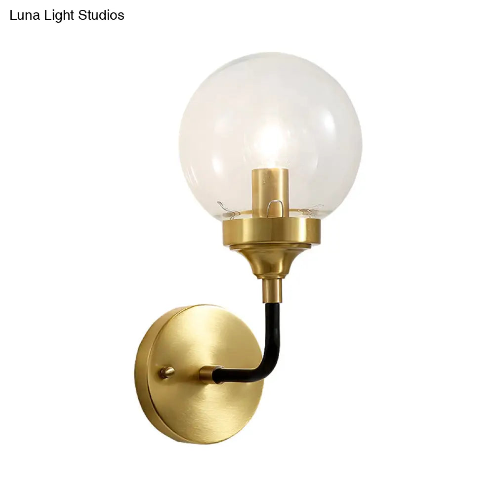 Clear Glass Globe Wall Sconce Light Fixture - Simple Brass With Curved Arm