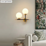 Post-Modern White Glass Sphere Wall Sconce With Brass Finish - 1/2 Bulbs